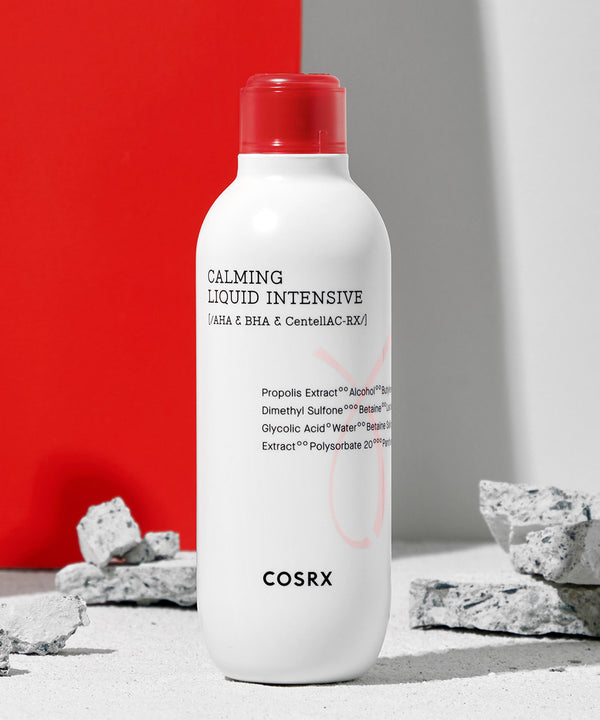 ProtoClinical k-beauty COSRX AC Collection Calming Liquid Intensive 125ml single upright treatment bottle centered on a white background with soft red and gray accents